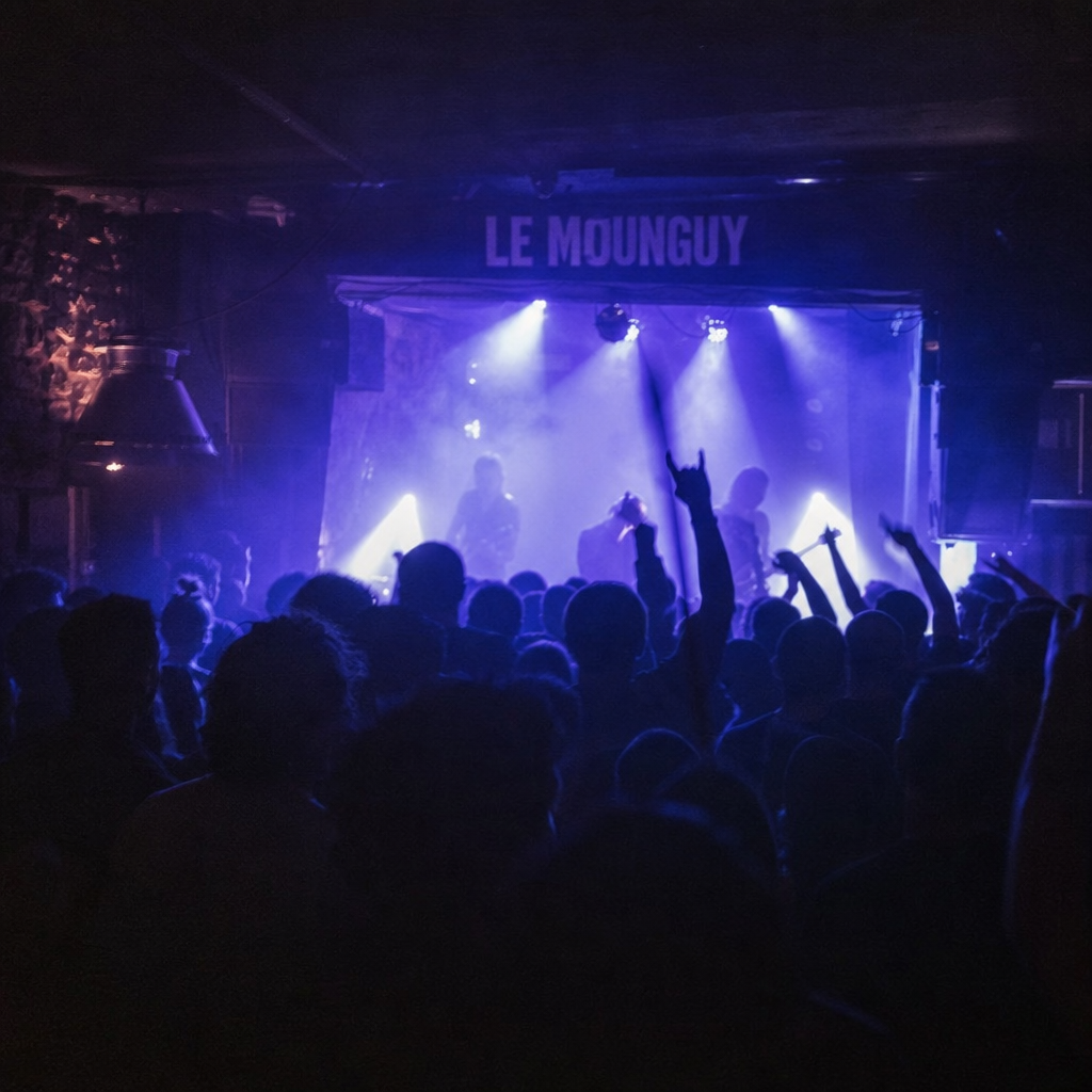 Ambiance électrique au Mounguy Marseille, foule vibrante, lumières de concert et cocktails abordables.